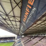 Banner installation on a football stadium stand roof