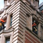 Rope access technicians working on a Victorian stone and brick building facade